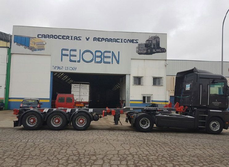 Un camión está estacionado frente a un edificio que dice feioben