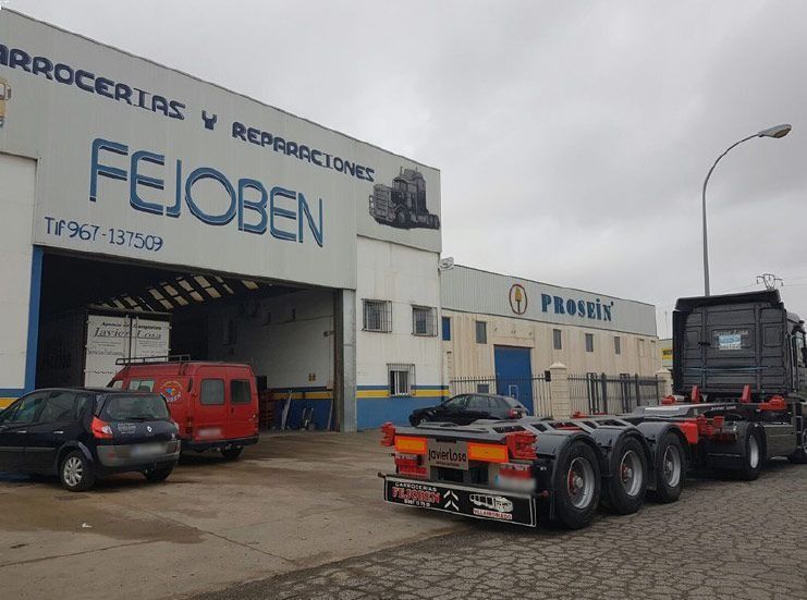 Un camión está estacionado frente a un edificio que dice fejoben