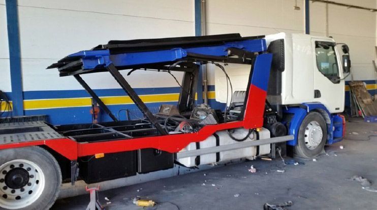 Una grúa roja, blanca y azul está estacionada en un garaje.