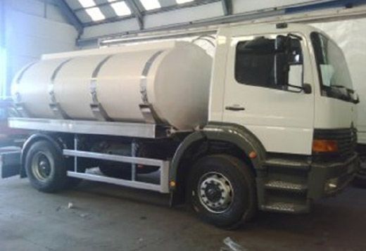 Un camión cisterna blanco está estacionado en un garaje.