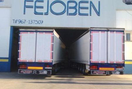 Dos camiones están estacionados frente a un edificio que dice fejoben