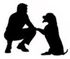 Silhouette einer hockenden Person und eines sitzenden Hundes, die sich mit ausgestreckter Pfote entgegenstrecken.
