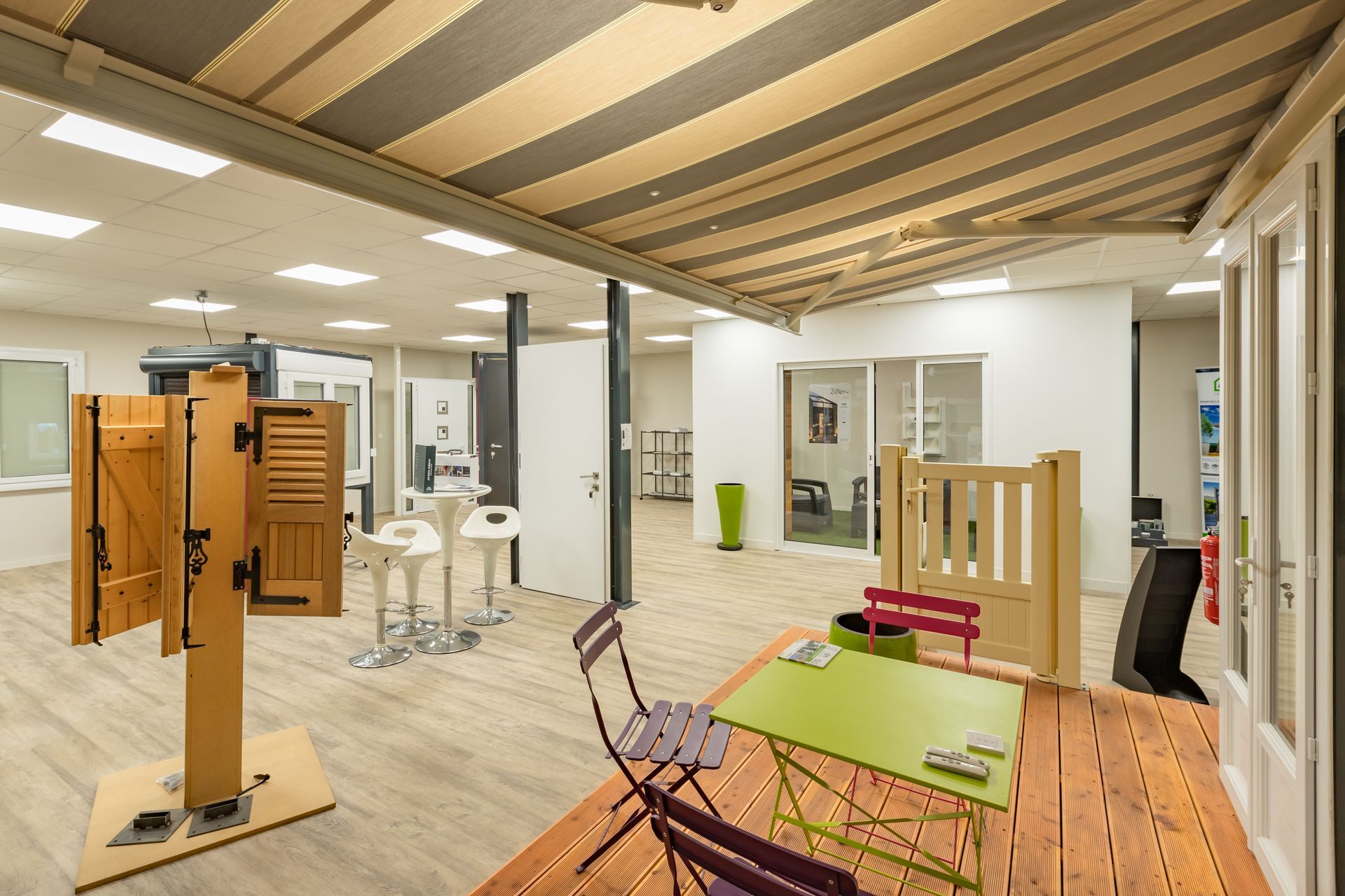 Vue du showroom avec des volets et un jardin d'été