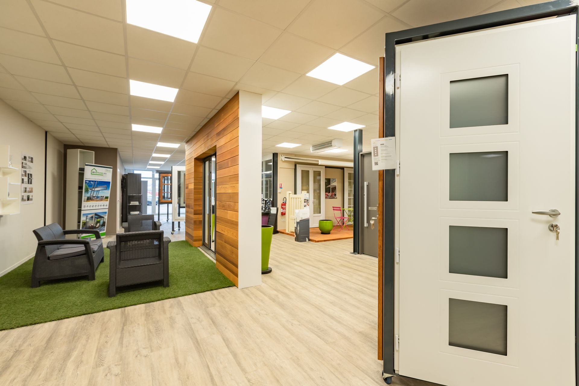 Vue du showroom avec une porte au premier plan et un salon d'été au second plan