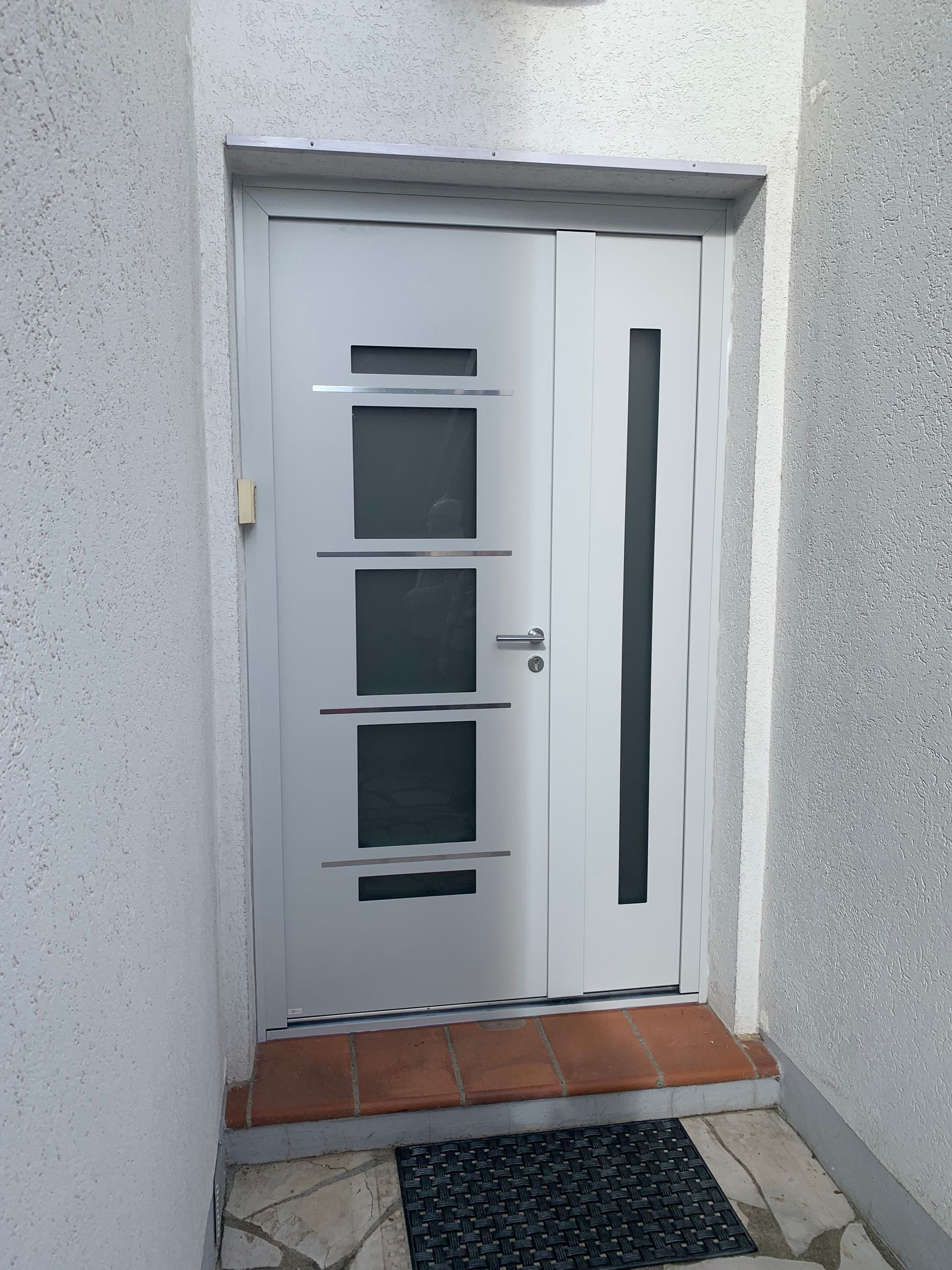 Porte d'entrée extérieur blanche avec des carreaux