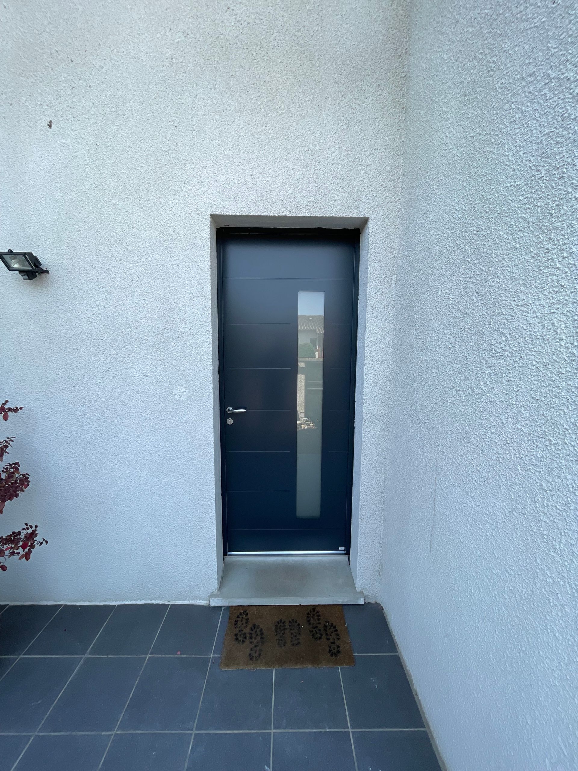 Porte d'entrée sur un mur en crépi 