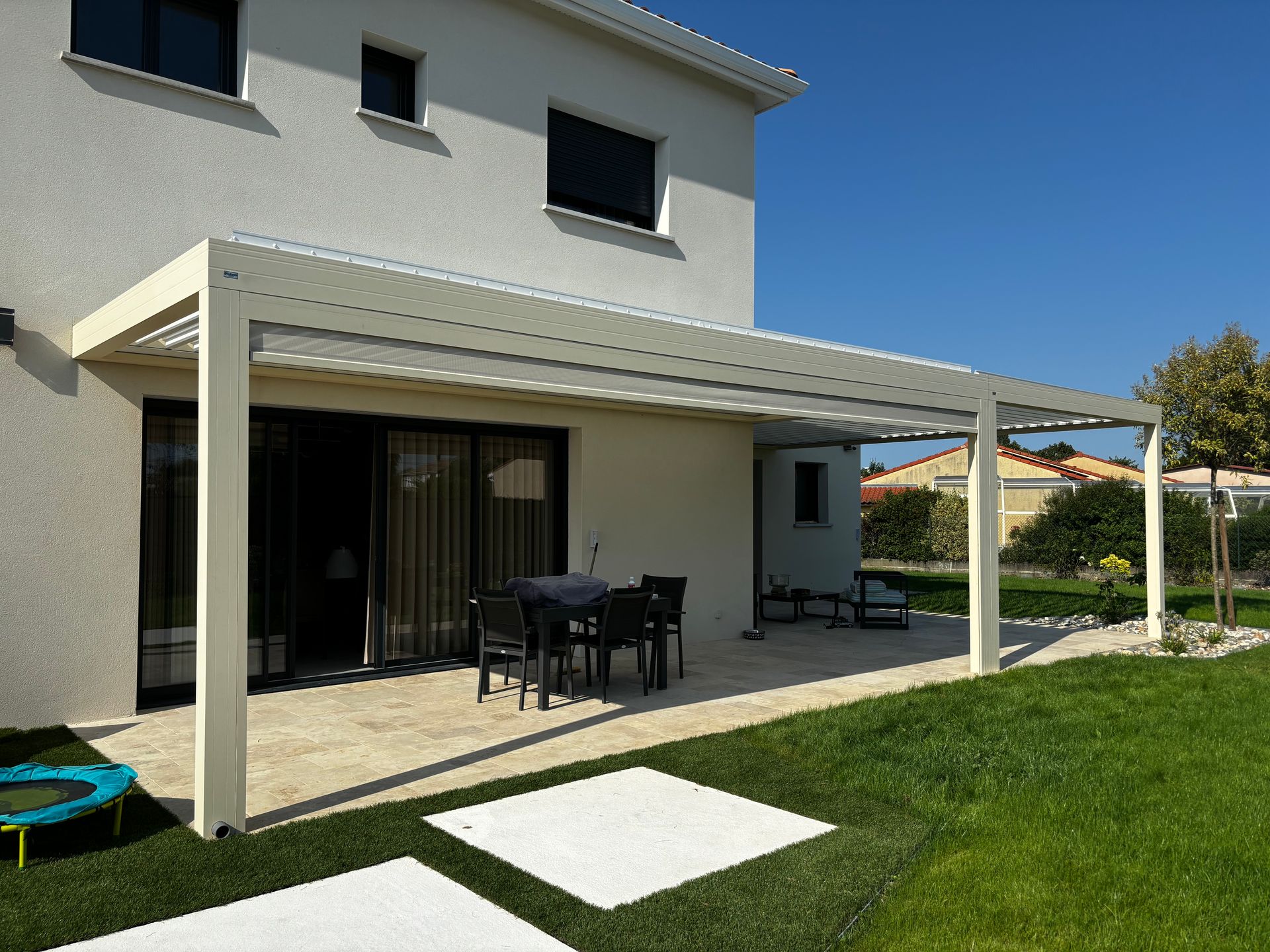 Pergola bioclimatique sur une terrasse avec un salon de jardin