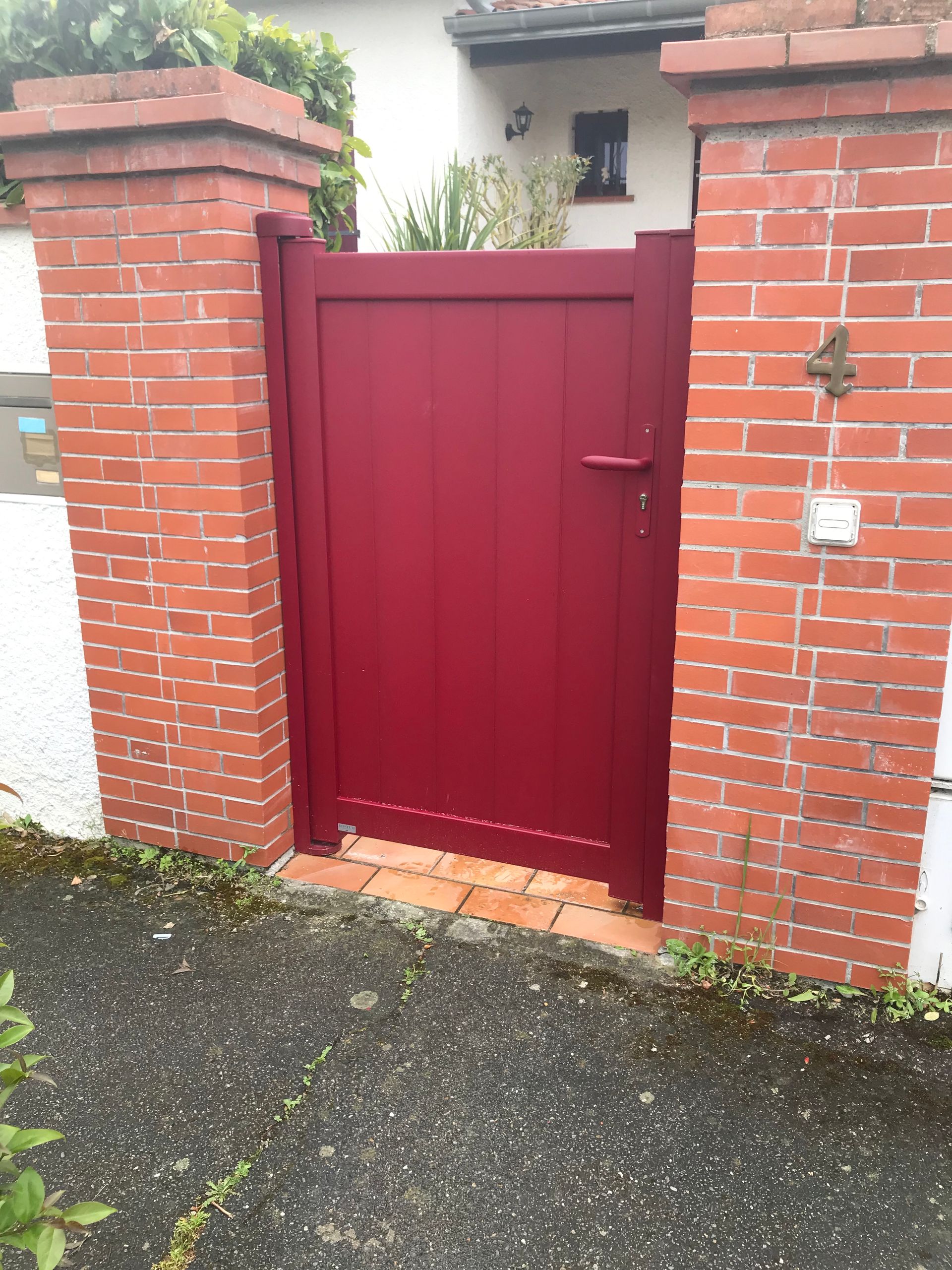 Porte d'entrée rouge dans un mur en brique