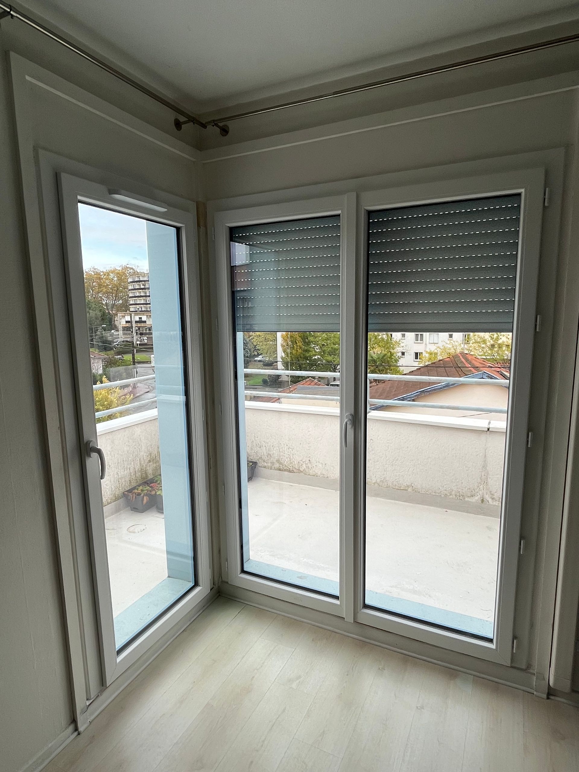 Vue de l'intérieur d'une maison d'une porte vitrée avec brise-soleil à demi fermé