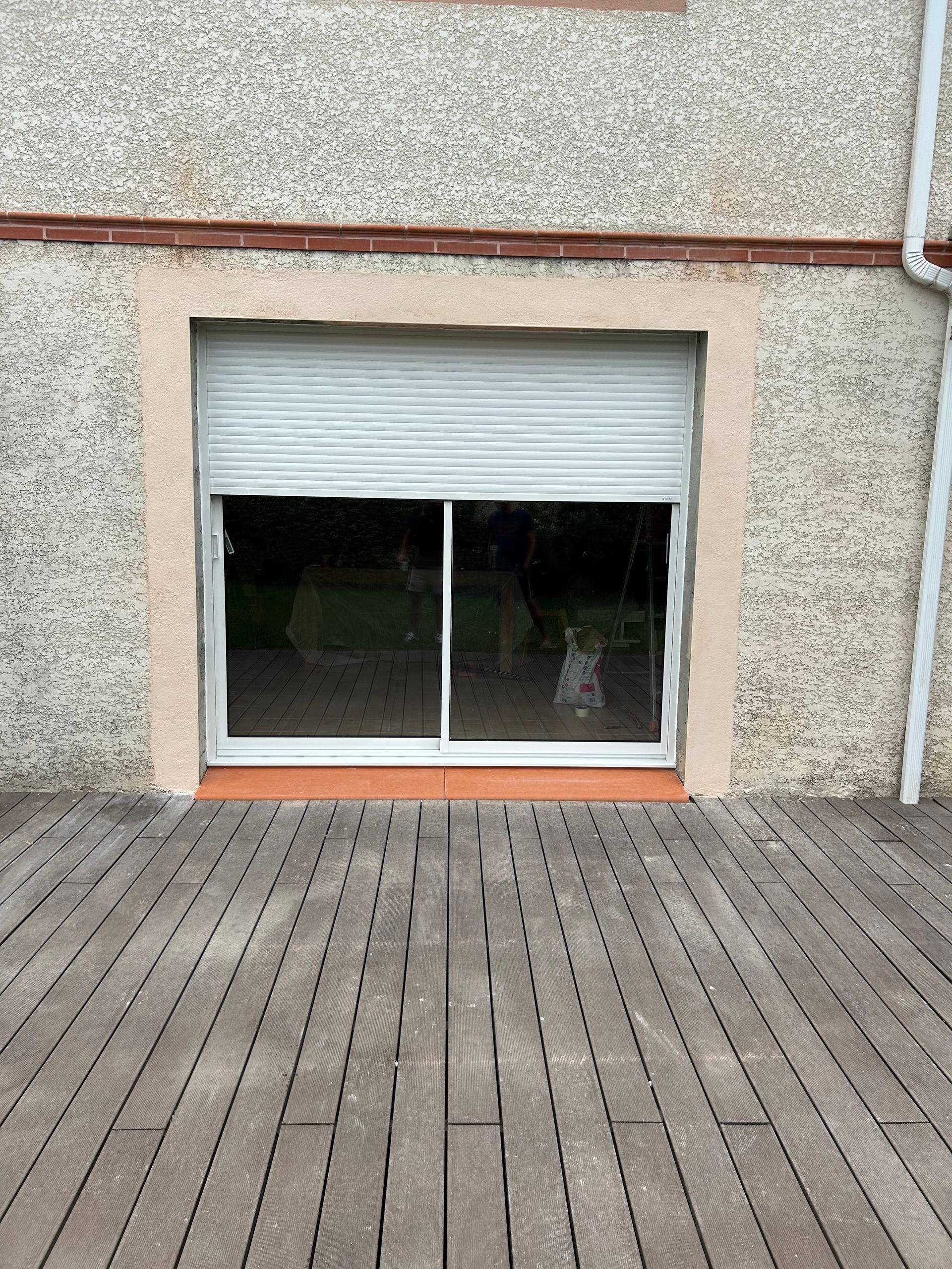 Brise-soleil à demi fermé protégeant une baie vitrée