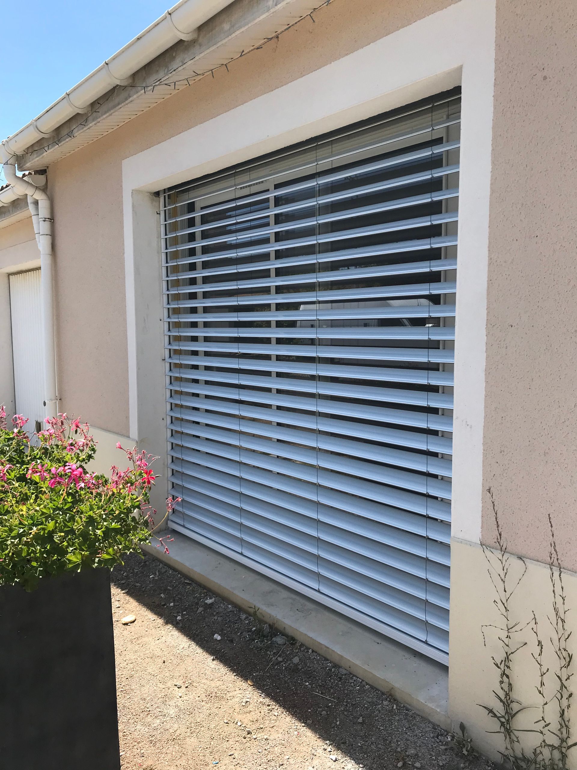 Brise-soleil semi-ouvert devant une ouverture