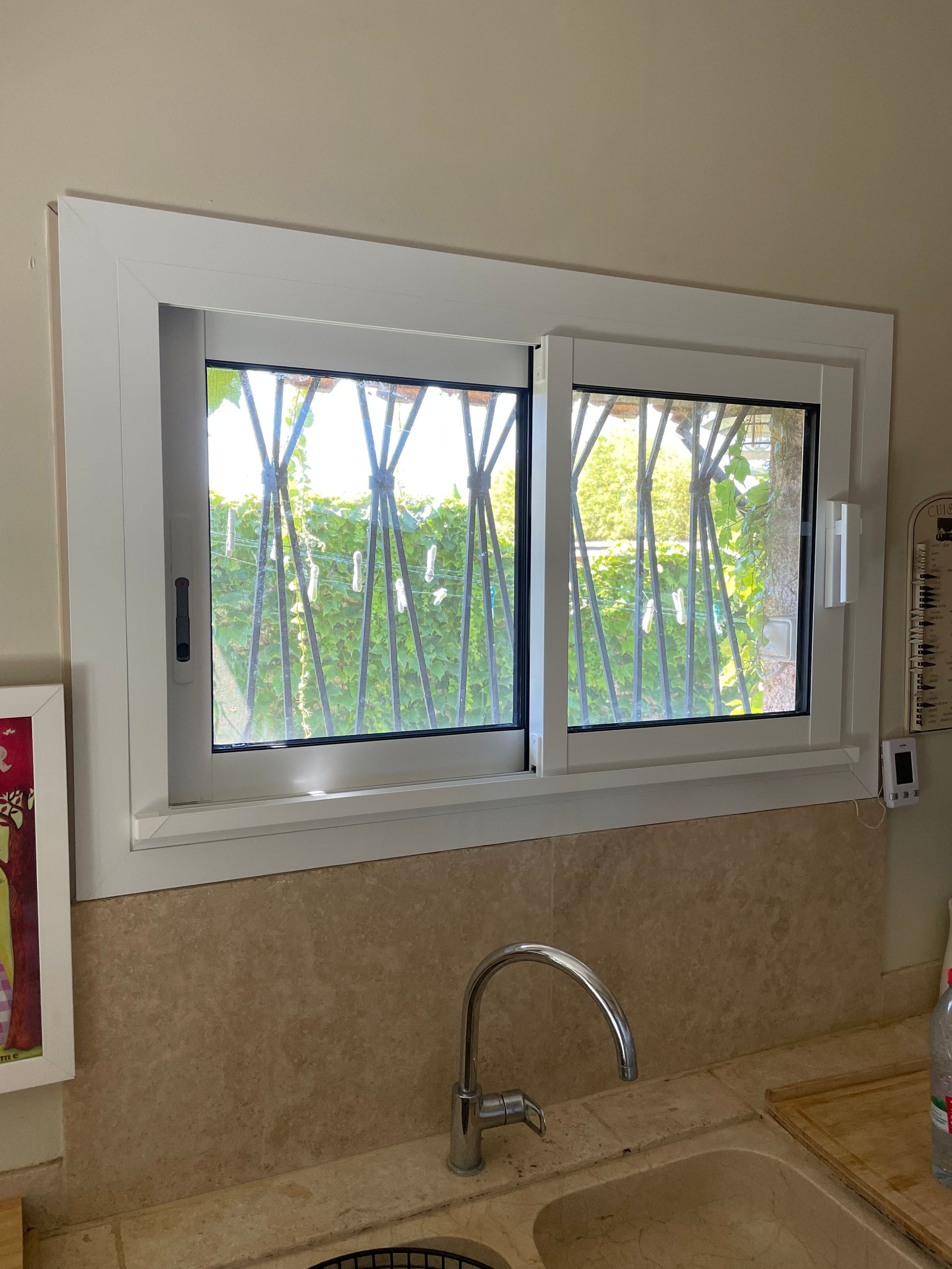 Grande fenêtre coulissante donnant sur un jardin