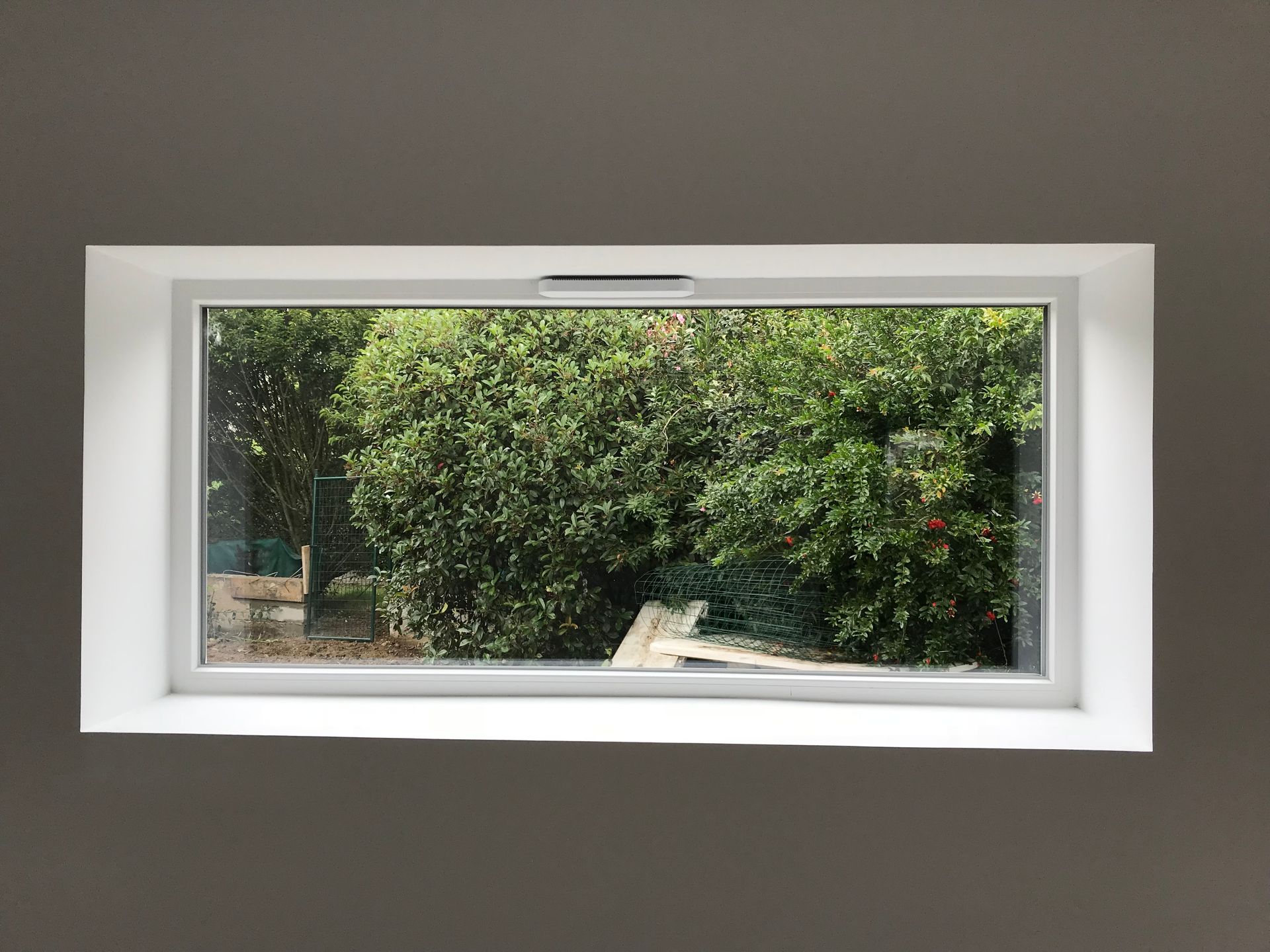 Grande fenêtre panoramique qui donne sur un jardin