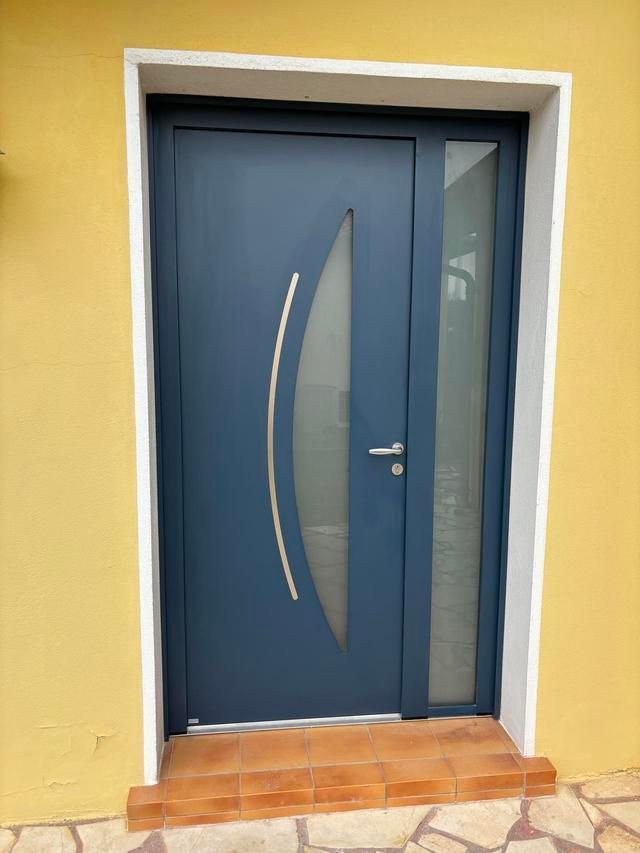 Porte d'entrée bleue sur un mur jaune