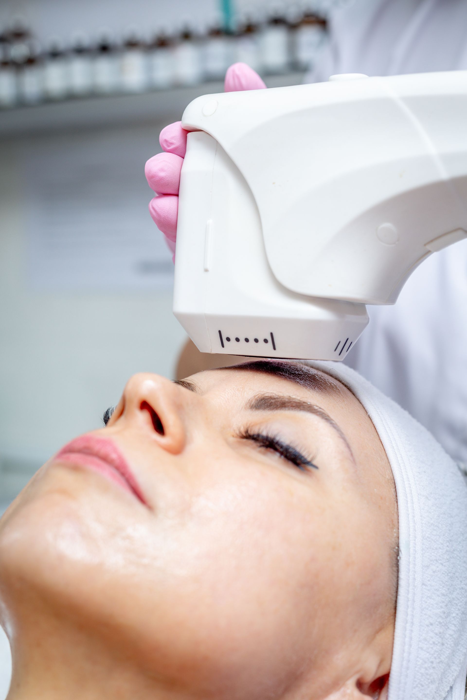 Une personne en train d'effectuer un soin HIFU sur un visage.