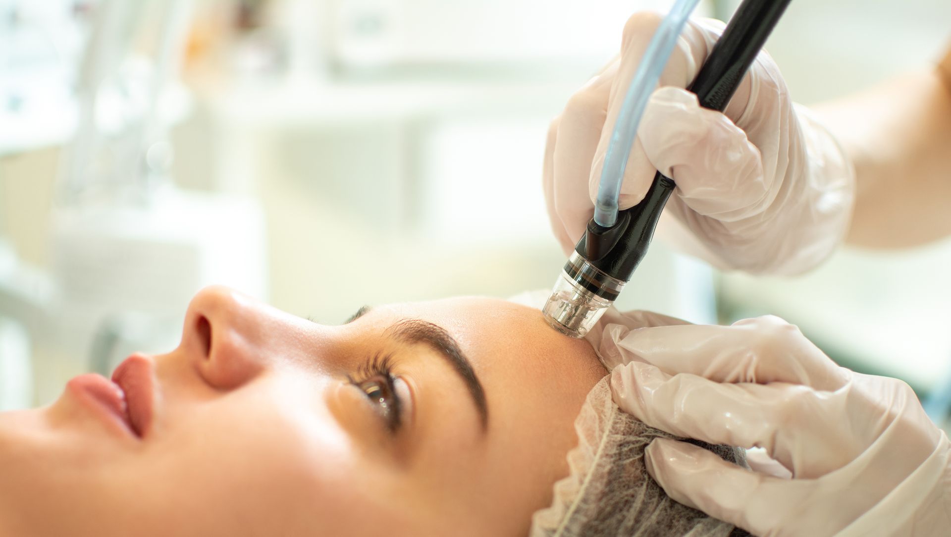 Une personne appliquant un soin sur le visage d'une femme.