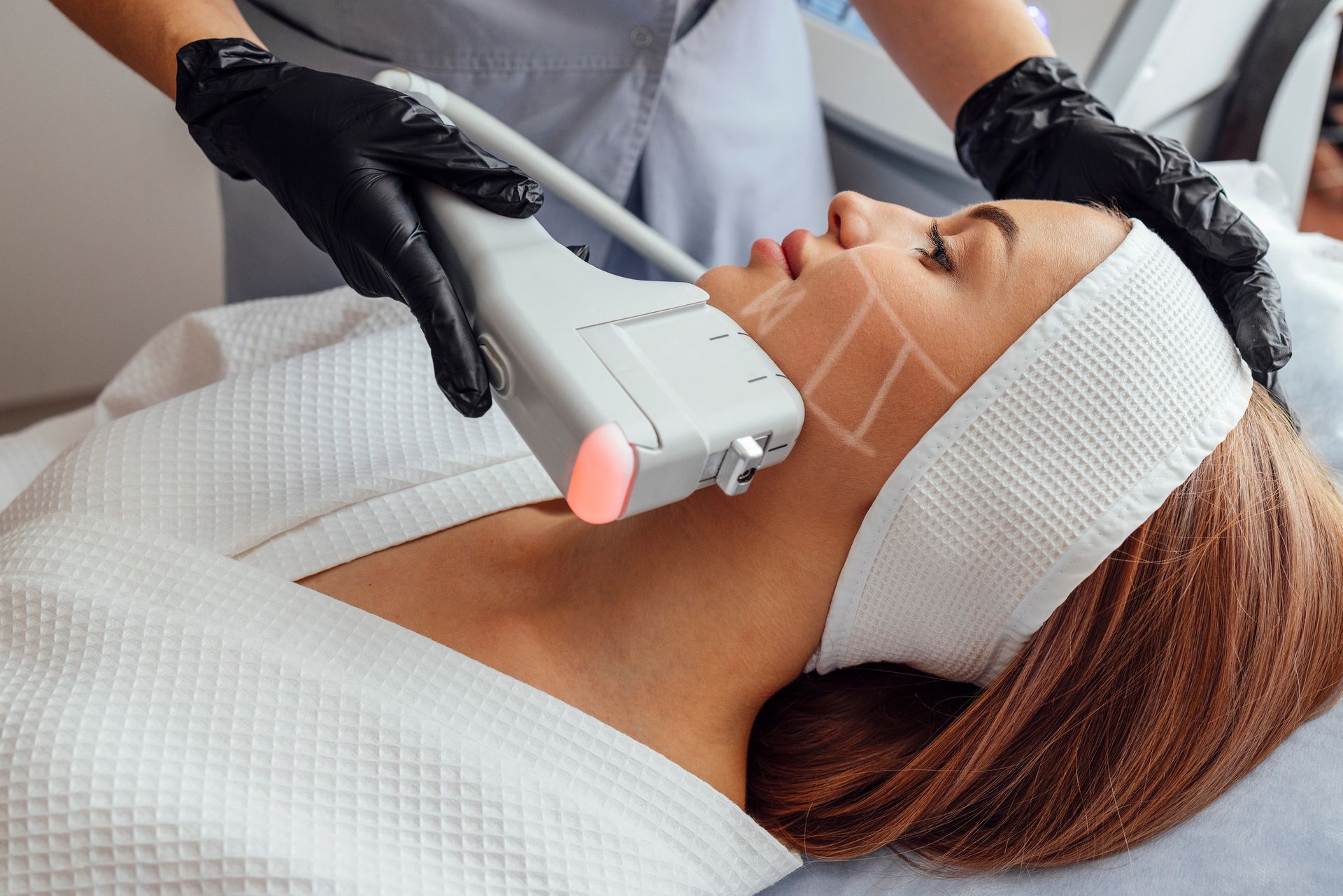 Une femme recevant un soin sur le visage.