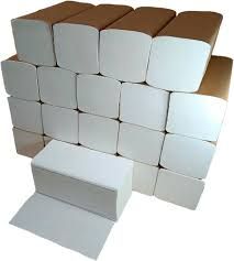 Pila de toallas de papel blanco en dispensadores de cartón marrón.