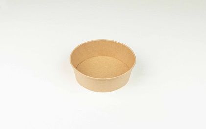 Cuenco de papel marrón para comida sobre una superficie blanca.