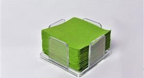 Servilletas cuadradas verdes en soporte de acrílico transparente sobre superficie blanca.