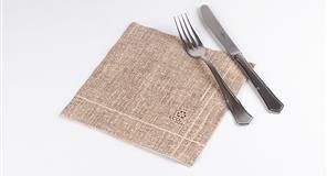 Tenedor y cuchillo sobre una servilleta de lino color marrón, todo sobre un fondo blanco.