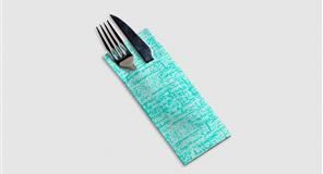 Tenedor y cuchillo en un porta utensilios de papel color verde azulado sobre una superficie blanca.