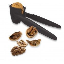 Cascanueces negro con nueces y nueces sin cáscara sobre una superficie blanca.