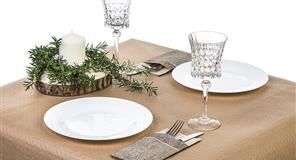 Decoración de mesa con platos blancos, copas de cristal y centro de mesa con vela.