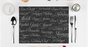 Decoración del comedor: mantel individual con saludos en varios idiomas, con cubiertos y vaso.