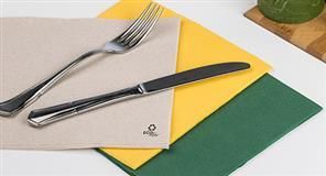 Tenedor y cuchillo sobre servilleta beige, con servilletas amarillas y verdes.