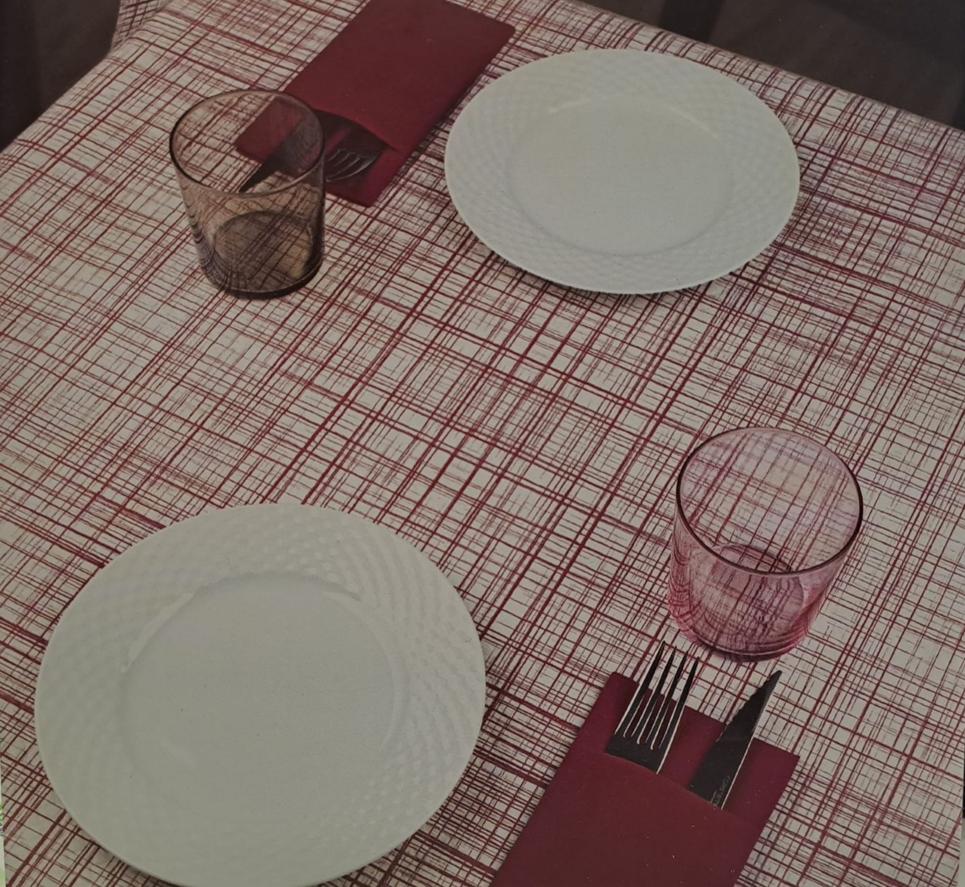 Artículos de limpieza en un balde blanco: botella con atomizador, jabón para platos, paños verdes y morados y un mango.