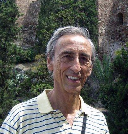 Un hombre con una camisa a rayas sonríe a la cámara.