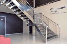 Una escalera con barandilla de acero inoxidable en un edificio.