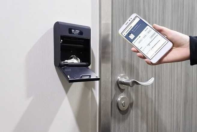 Una persona está usando un teléfono inteligente para abrir una puerta.