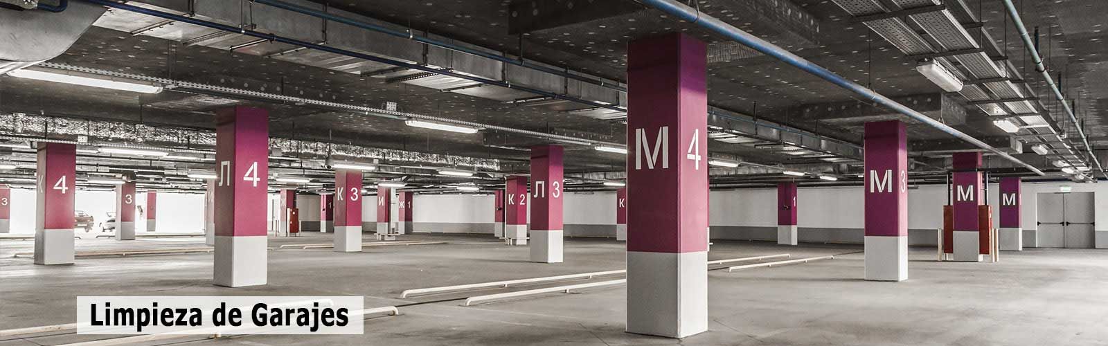 Un estacionamiento vacío con columnas rosas y blancas y un cartel que dice limpieza de garajes.