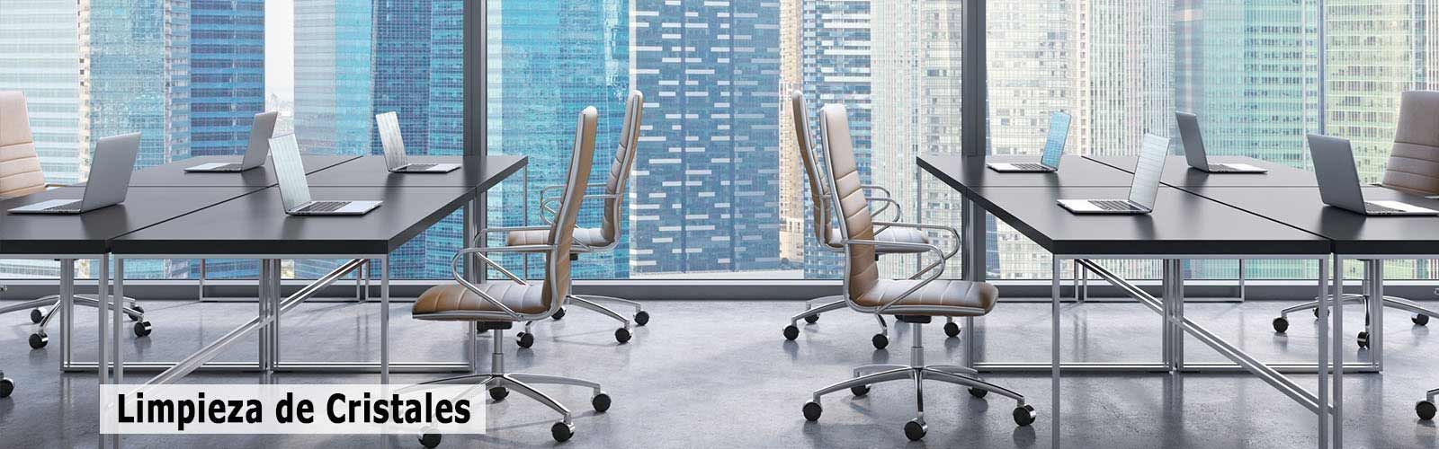 Una oficina con mesas y sillas y un cartel que dice limpieza de cristales.
