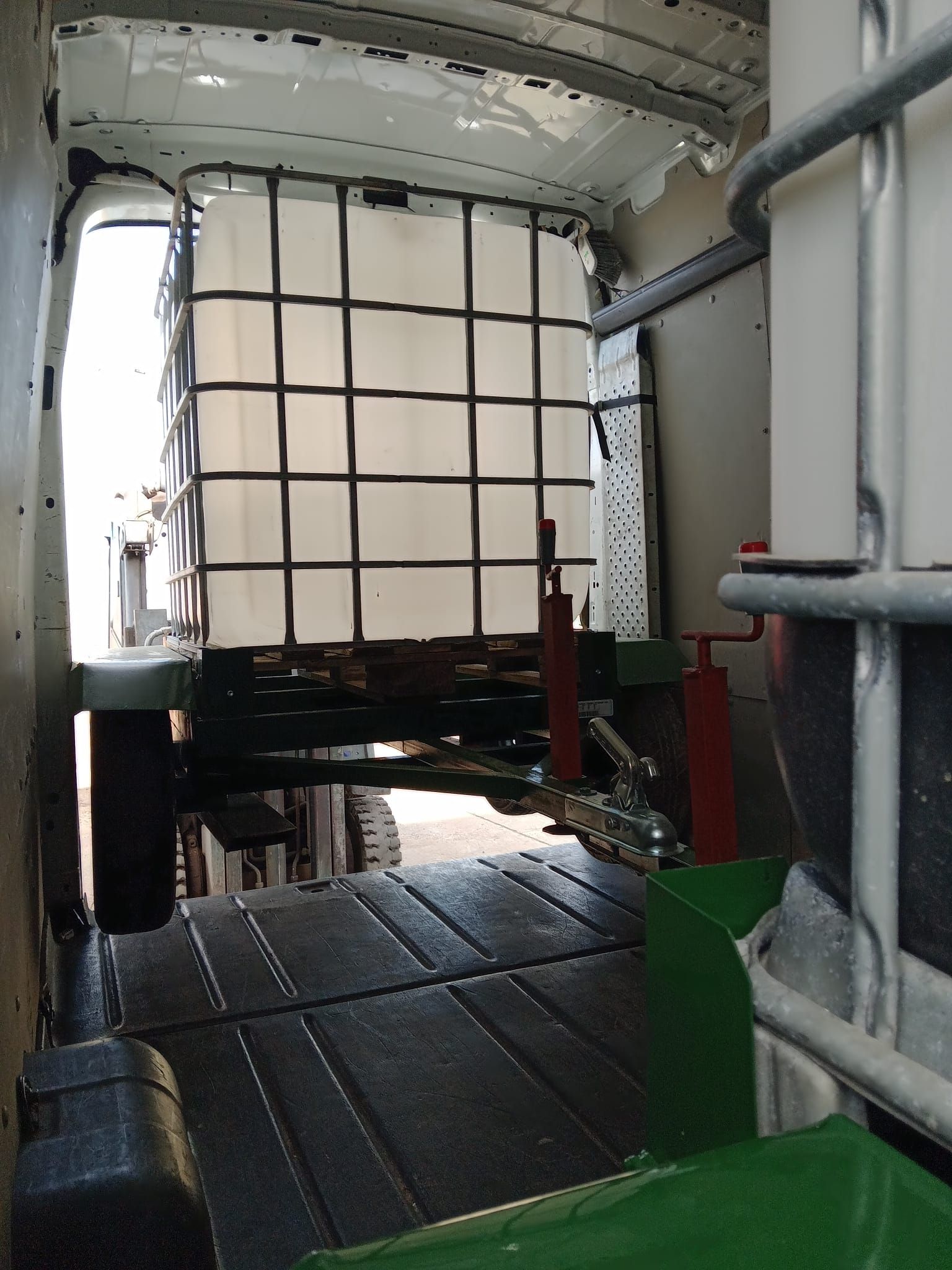 Una furgoneta blanca con un gran contenedor blanco en la parte trasera.