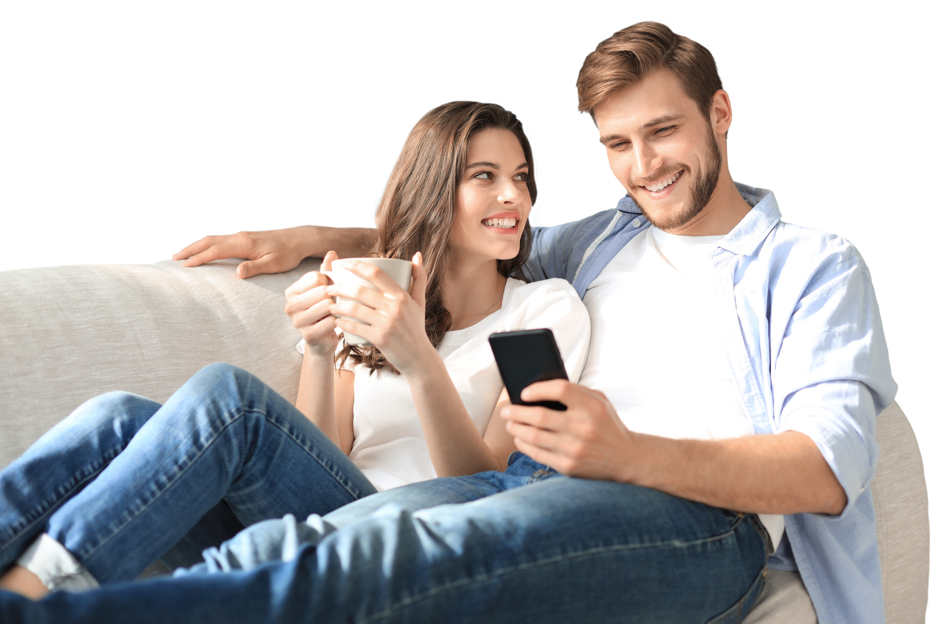 Un couple assis sur un canapé : elle porte une tasse de café, et lui tient un téléphone portable.