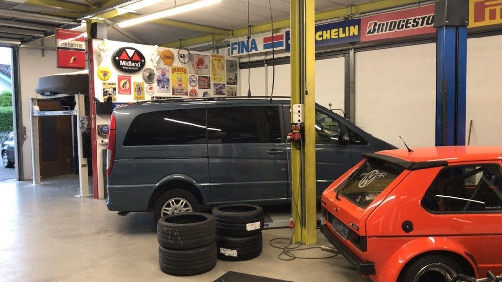 Person arbeitet an einer offenen Motorhaube