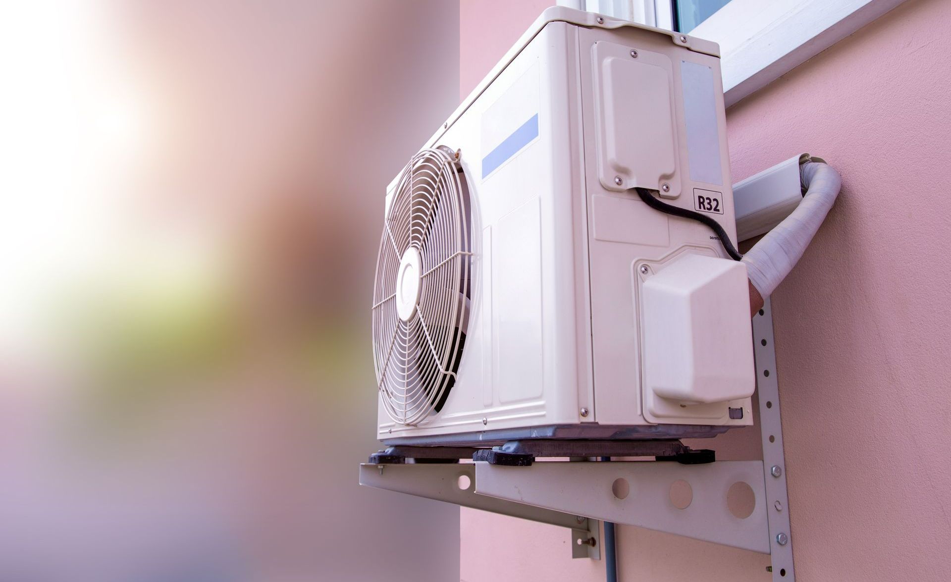 Unité extérieure de climatisation sur un mur rose