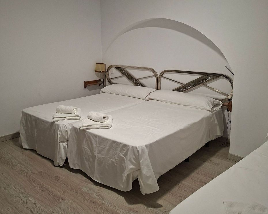 Un dormitorio con dos camas, una cómoda, un espejo y una ventana.
