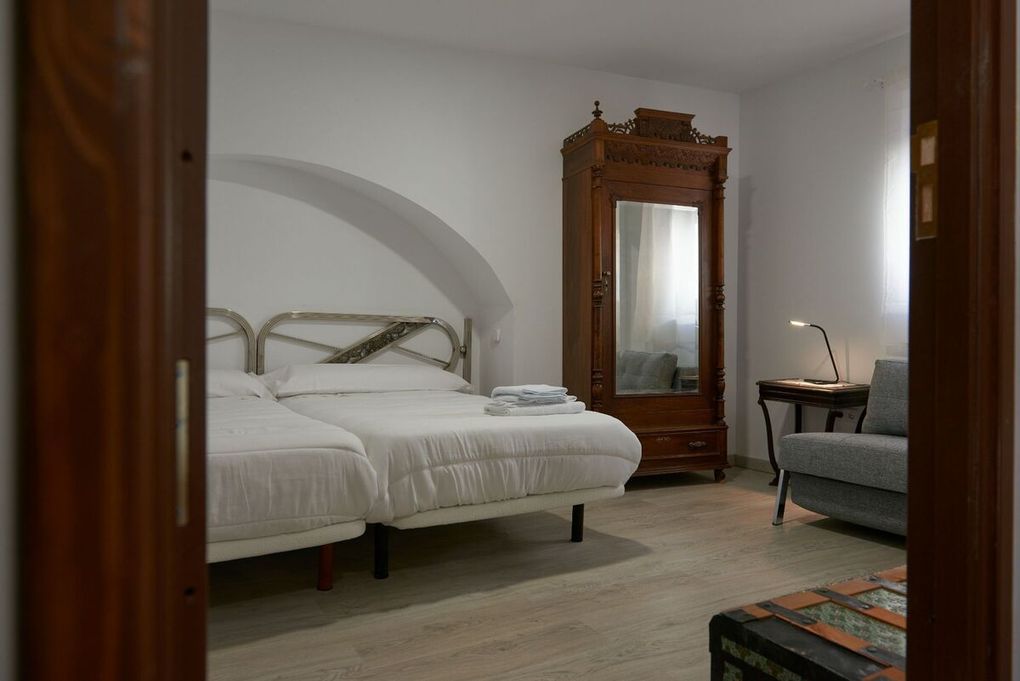 Un dormitorio con dos camas, una cómoda, un espejo y una ventana.