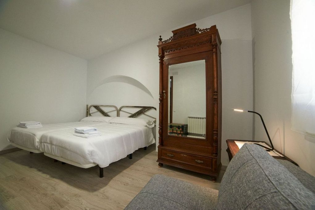 Un dormitorio con dos camas, una cómoda, un espejo y una ventana.