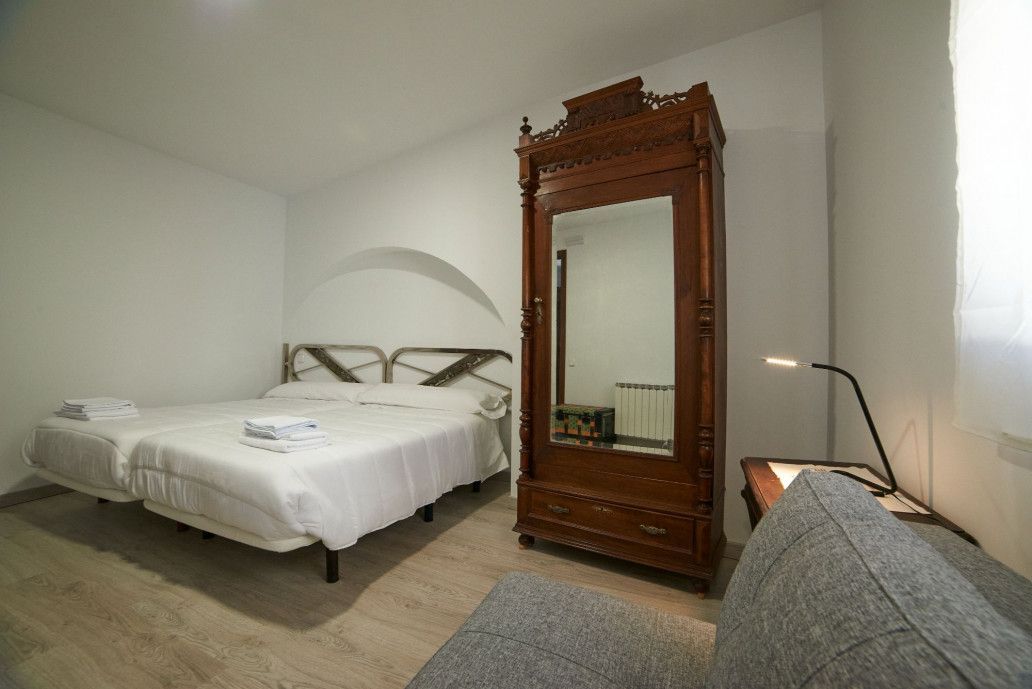 Un dormitorio con dos camas, una cómoda, un espejo y una ventana.