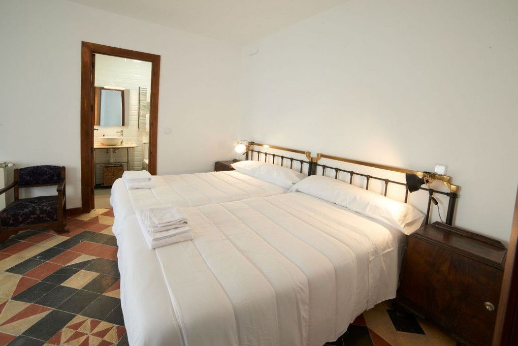 Un dormitorio con dos camas, una cómoda, un espejo y una ventana.