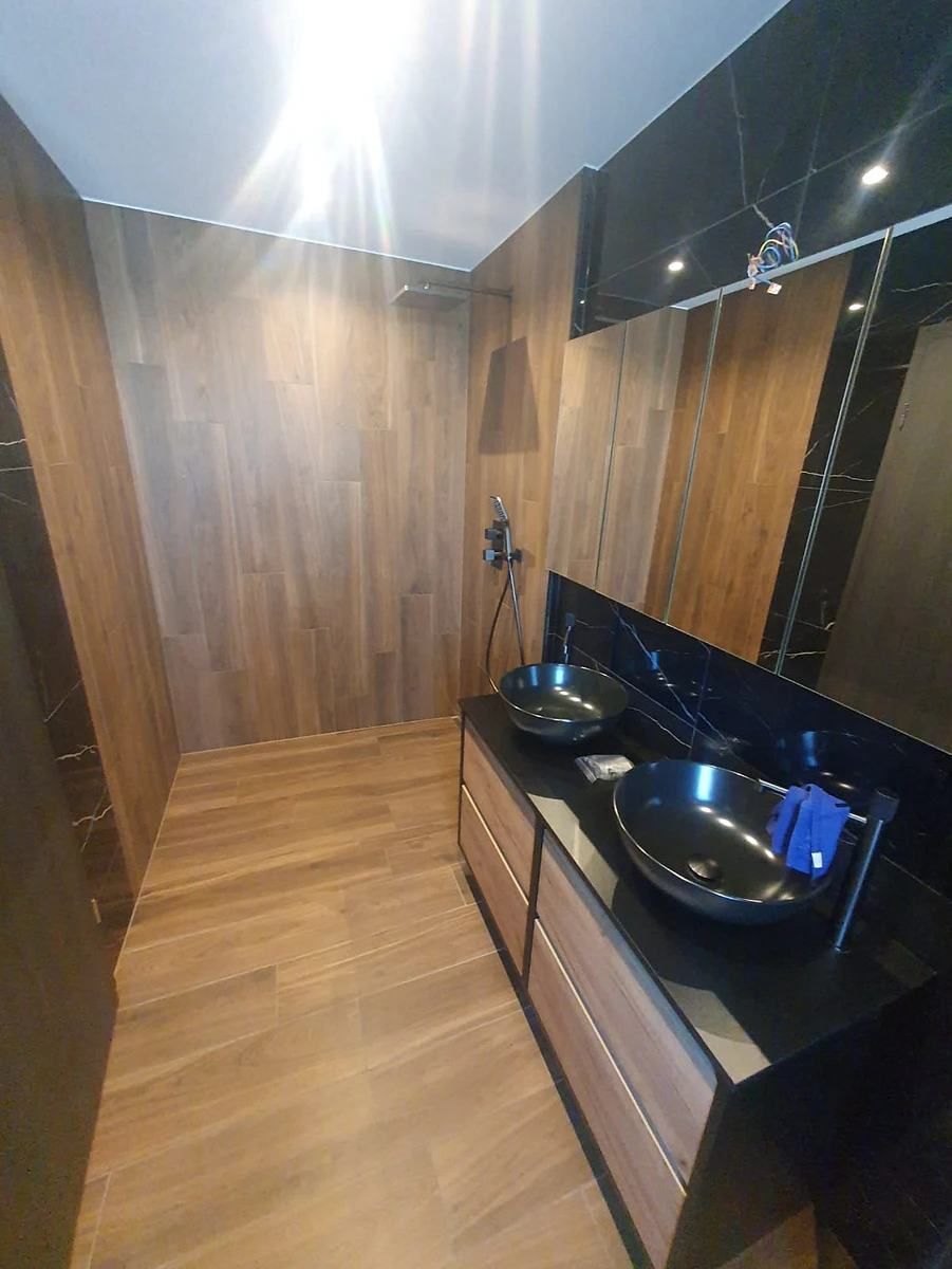 Une salle de bain avec deux lavabos et une douche.