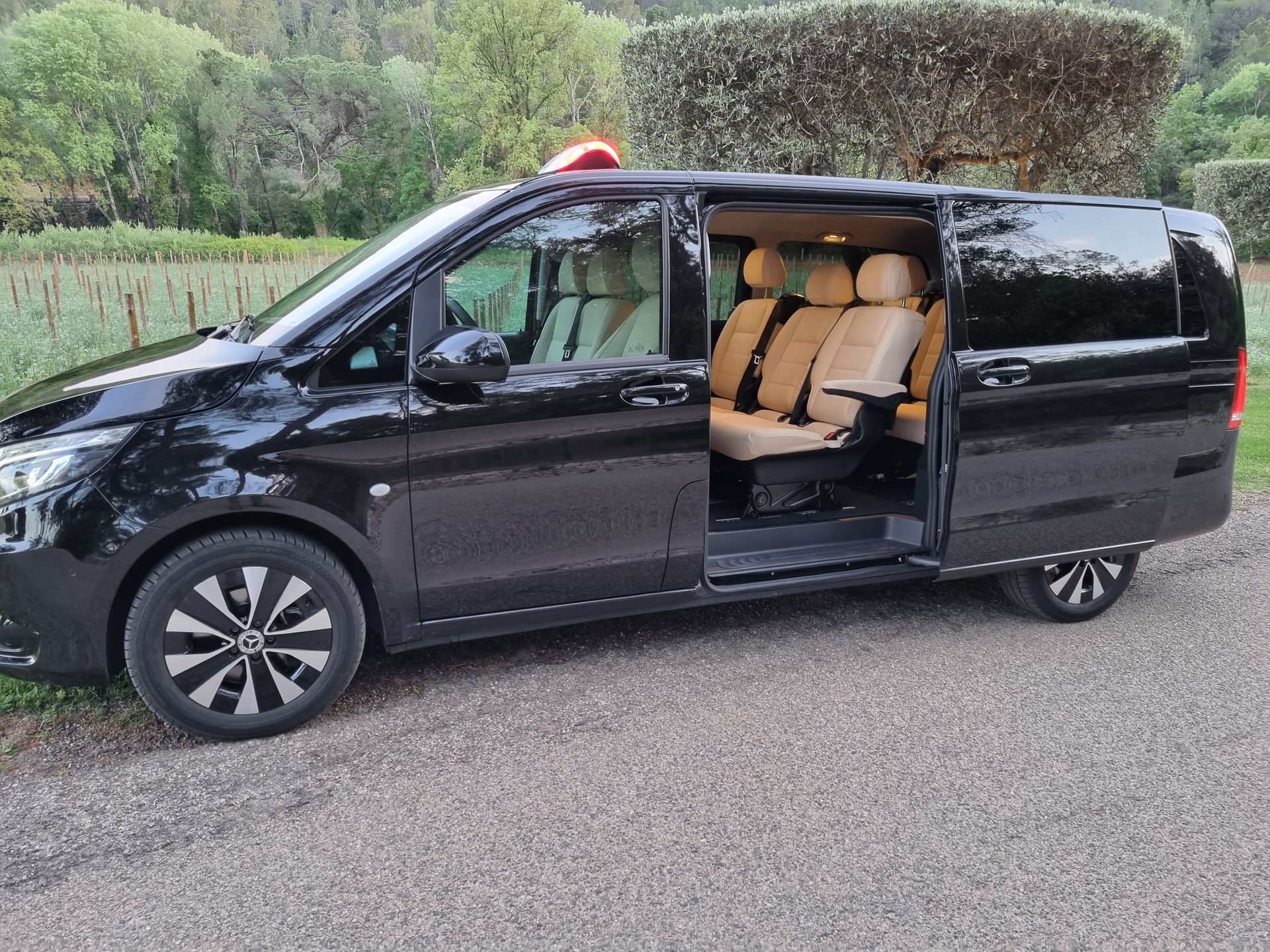 Van taxi vu de côté avec portière ouverte et sièges en cuir beige