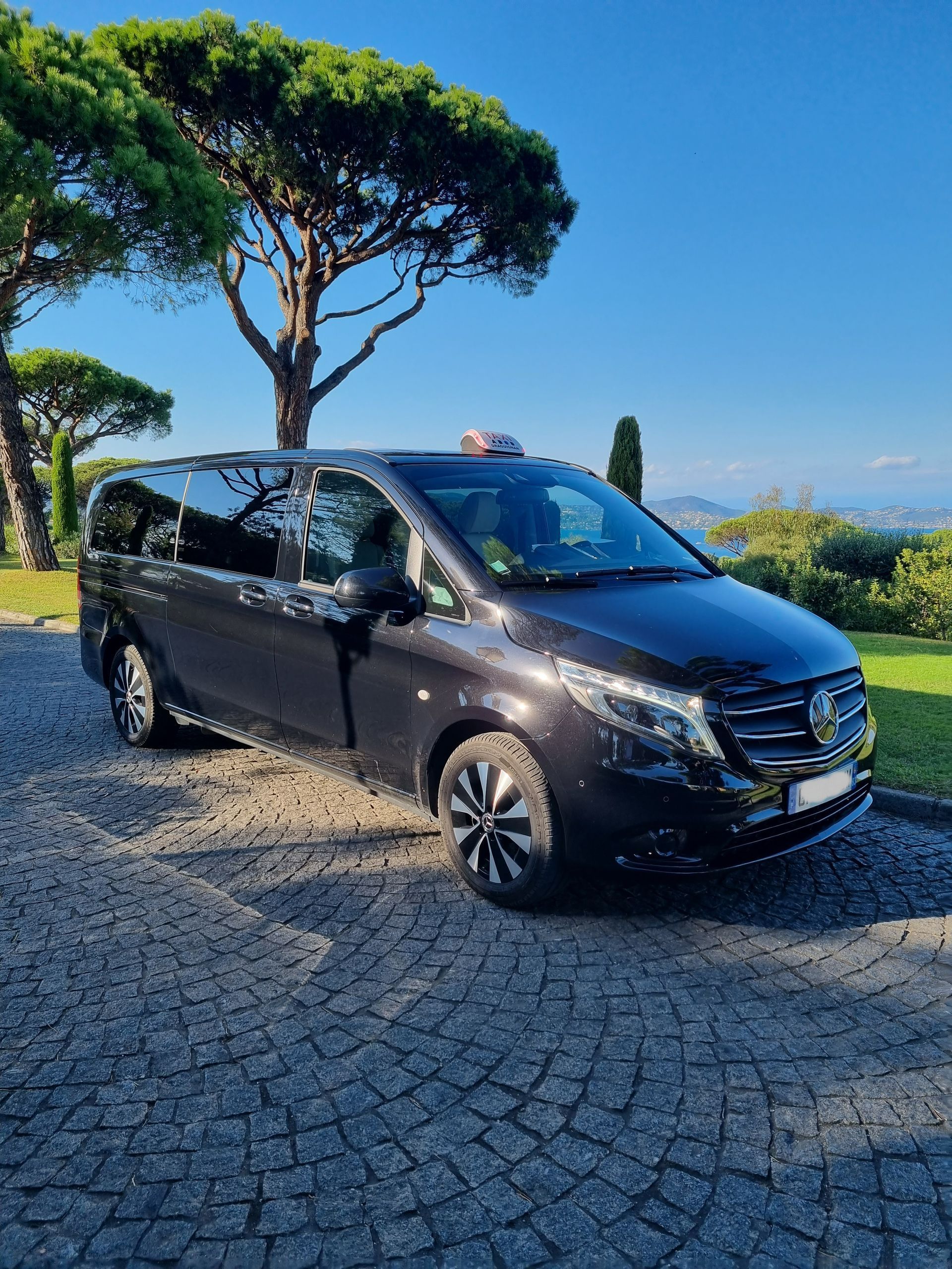 Van de luxe garé sur un parvis avec vue sur la Méditérranée