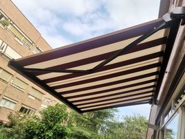 Un toldo a rayas cuelga del costado de un edificio.