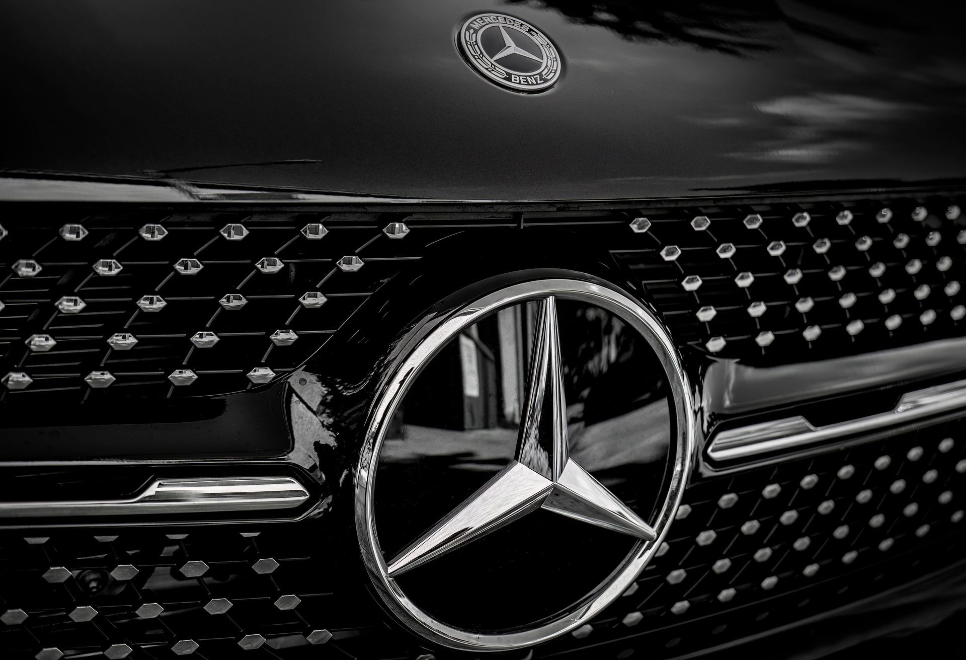 Close-up of a black Mercedes-Benz grille with chrome emblem and star logo